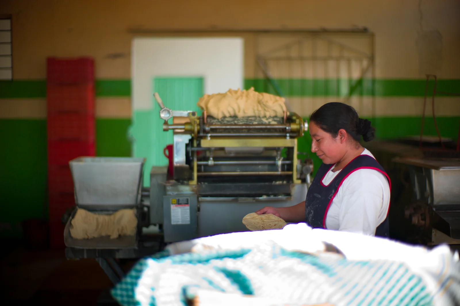 Tortilla maker working the masa