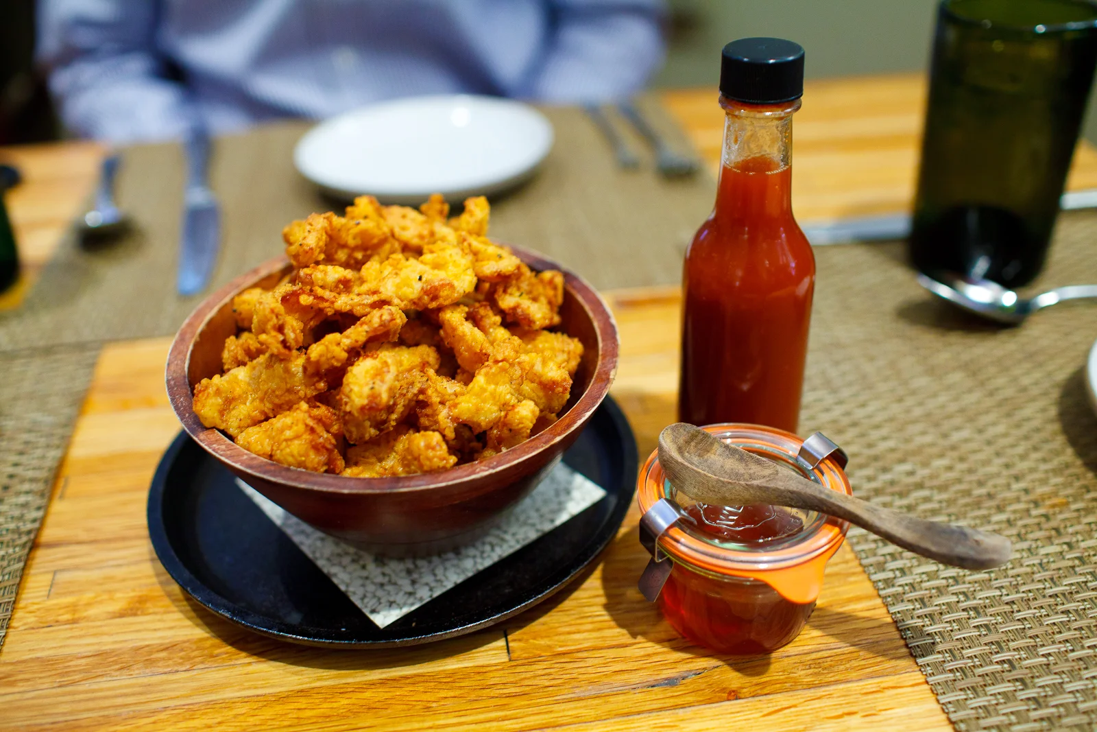 5th Course: Crispy chicken skins with honey and husk hot sauce.