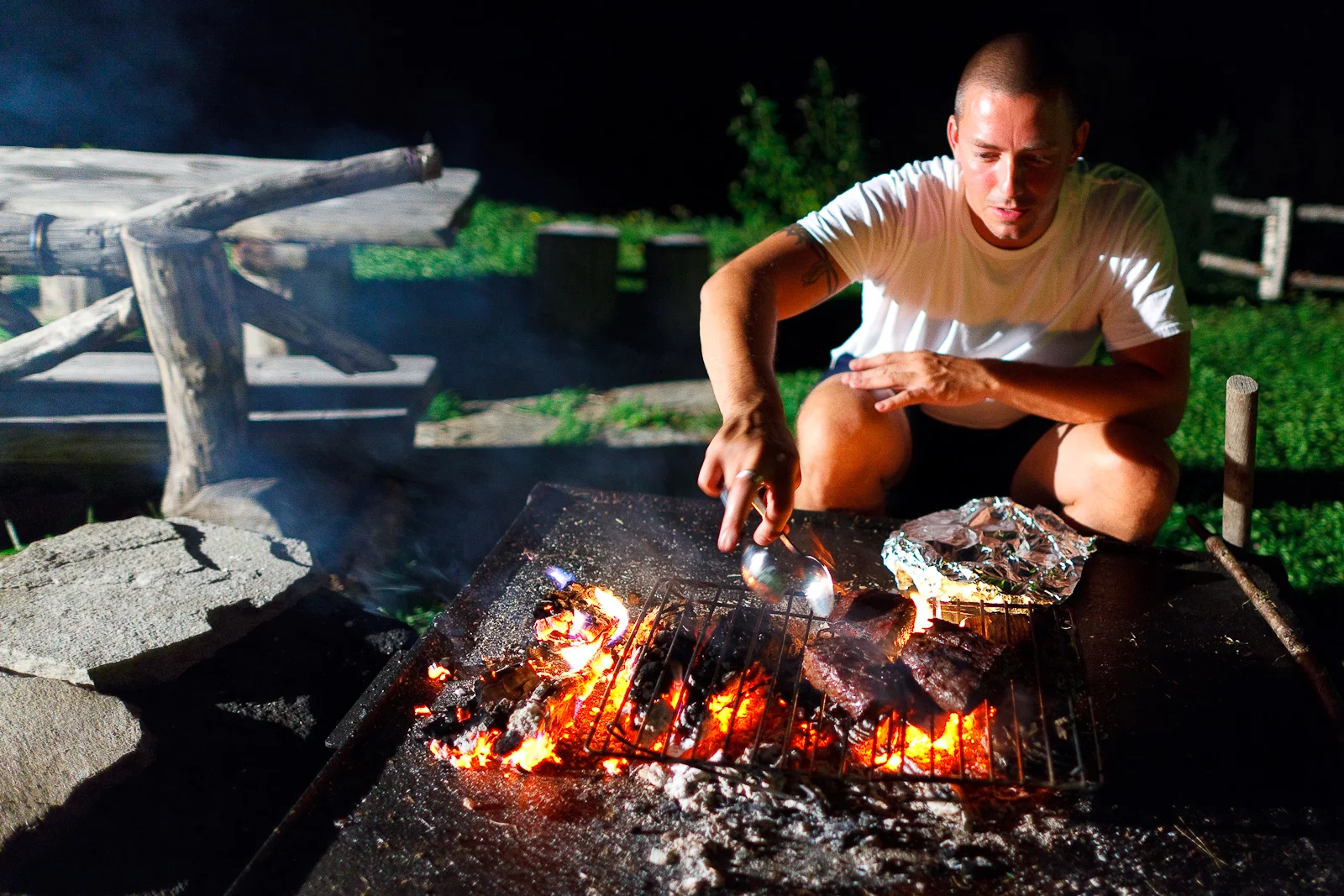 Chef Curtis Duffy grilling local rib eye over an open fire