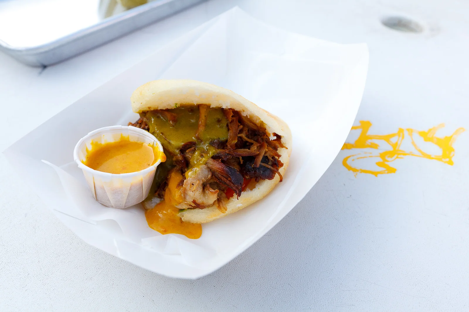 Arepa de pernil: roasted pork shoulder with tomato slices and spicy mango sauce ($7.25)