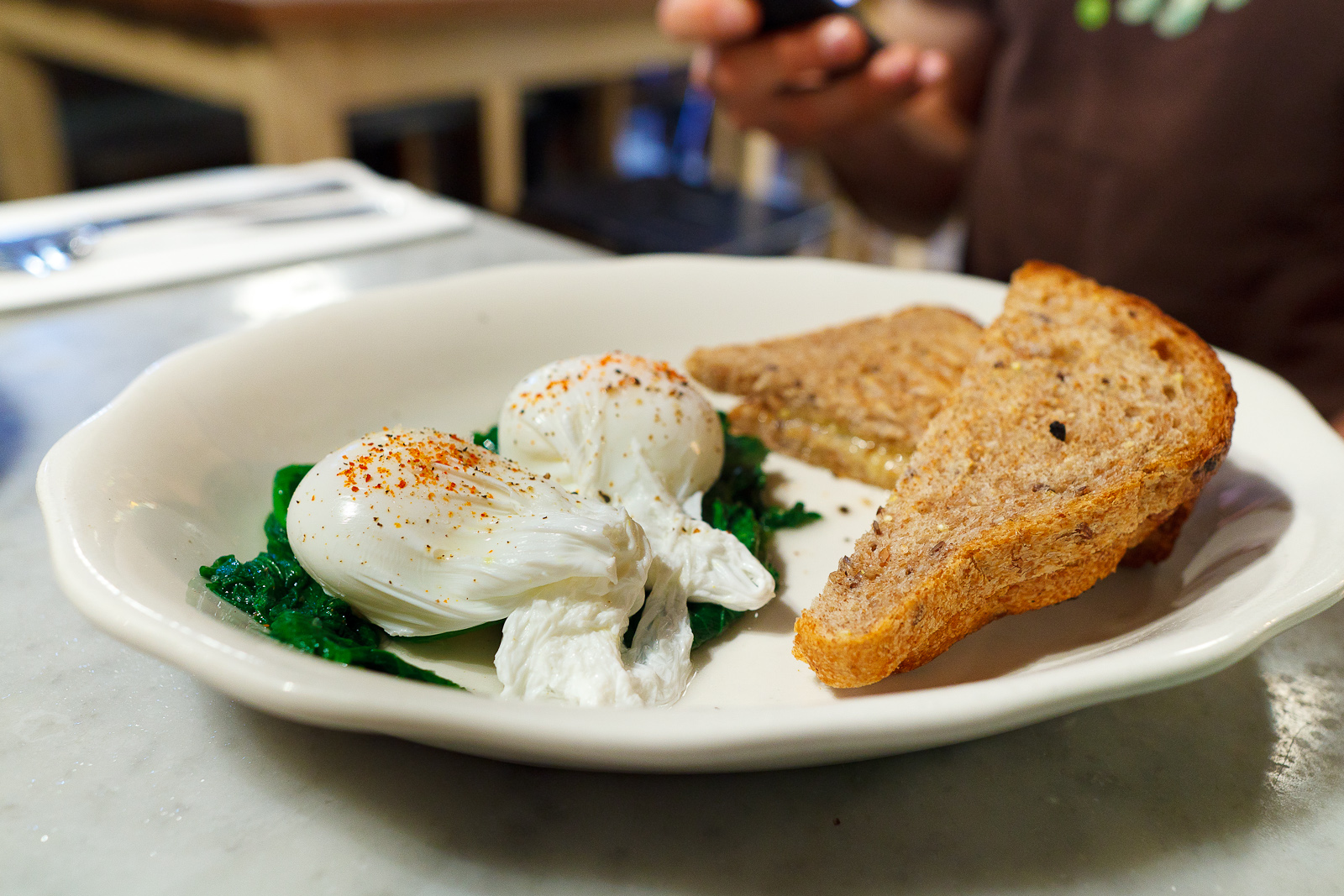 Eggs poached w/ sauteed greens & toast ($11)