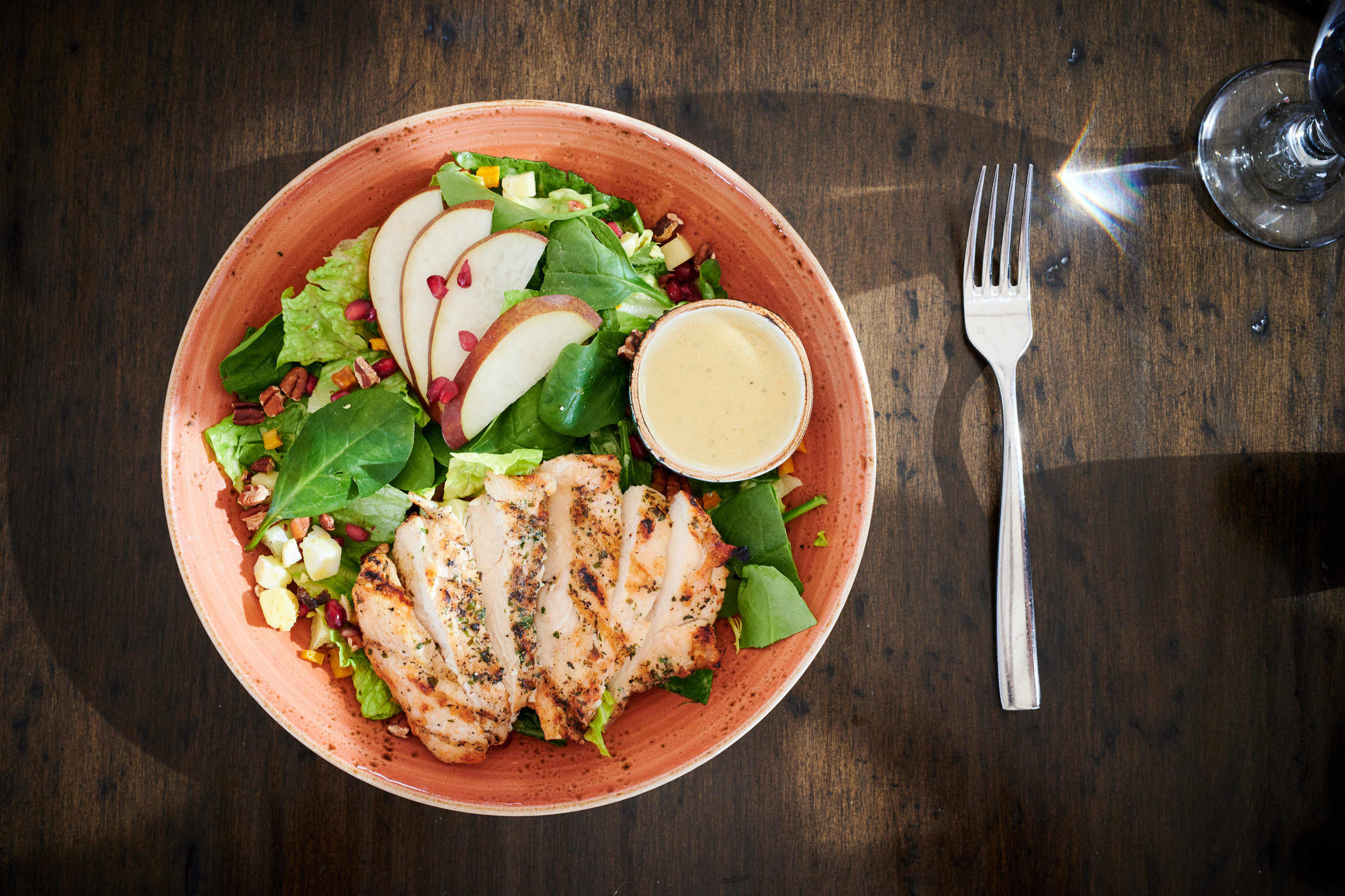 Harvest Cobb Salad with Grilled Chicken, Romaine, Mixed Greens, Grilled Pears, Bacon, Egg, Smoked Cheddar, Pomegranate, Butternut Squash, Pecans, Apple Cider Vinaigrette