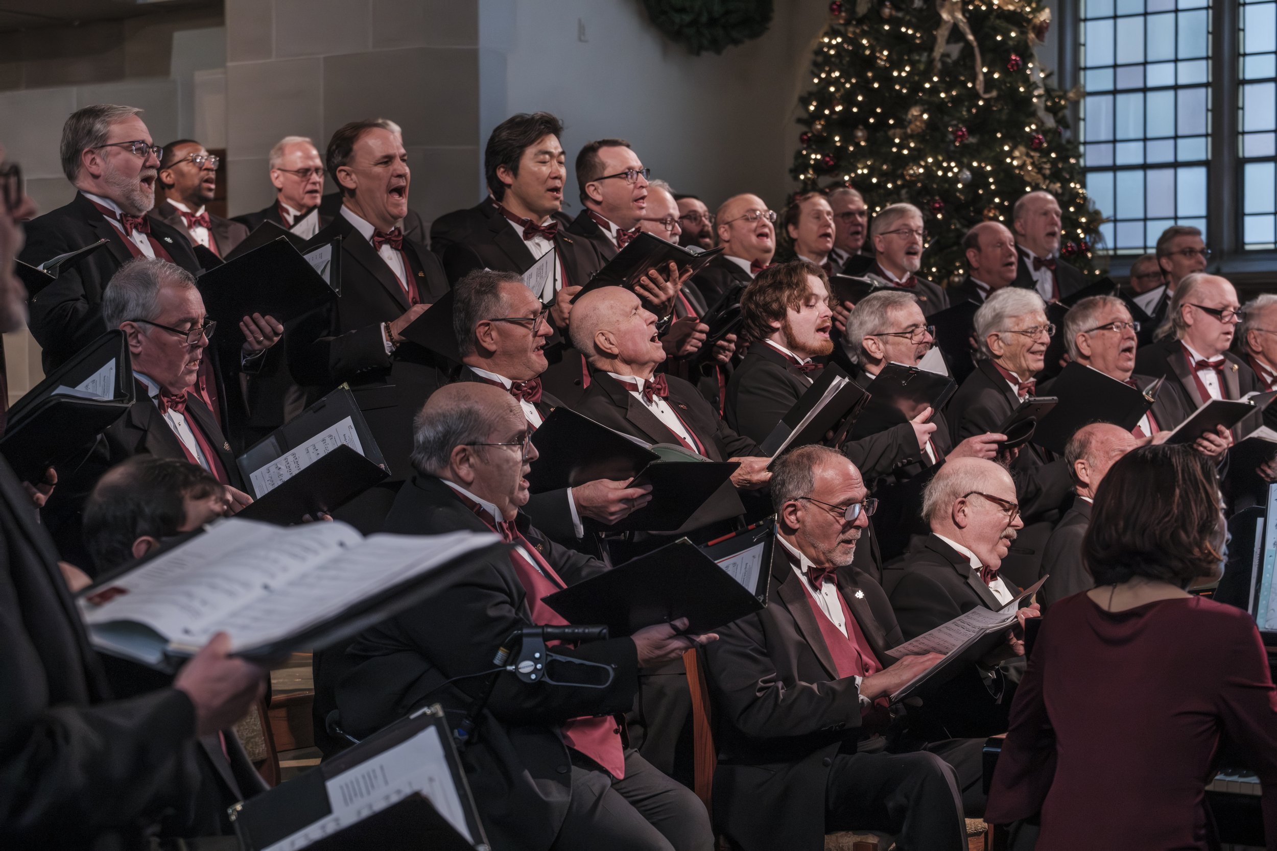 A candid photo of the Measure for Measure men's choir singing during their Songs of the Season concert in Ann Arbor