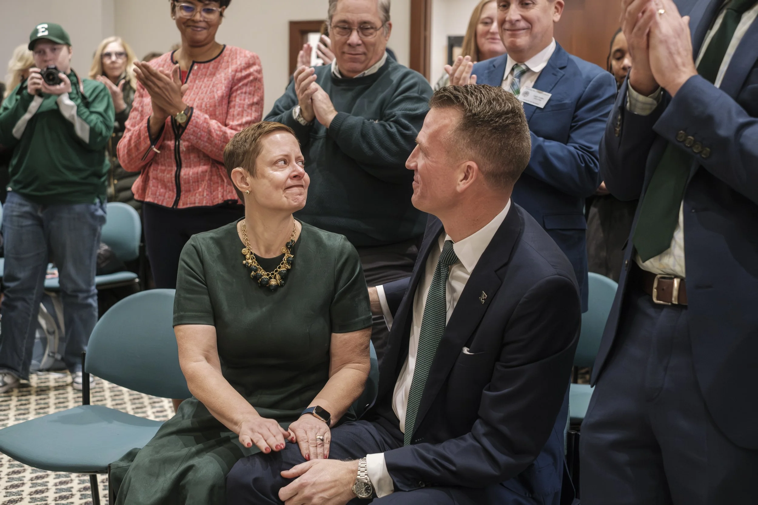 A photo documenting the emotion of Dr. Brendan Kelly and his wife, Dr. Tressa Kelly, while the board speaks, congratulating Dr. Kelly as he becomes the 24th president of Eastern Michigan University.