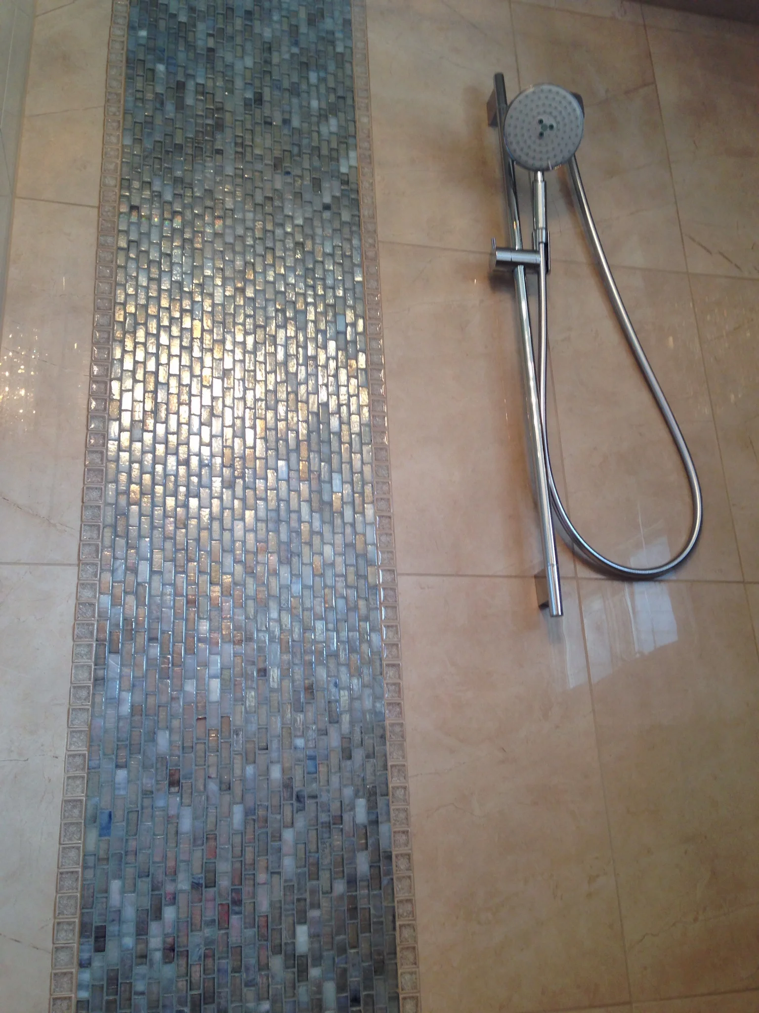 We used a really great luminescent tile for an accent in the shower. The wall tile is a 12x24 porcelain that is very similar to crema marfil marble. 