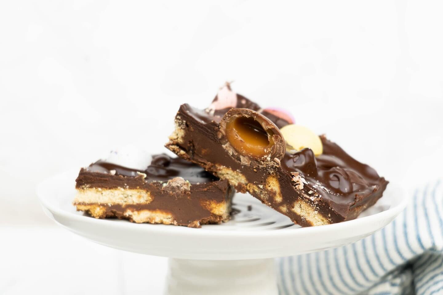 Tiffin is a sort of refrigerator cake, a dense, chocolatey, no-bake confection. Not exactly like an American style icebox cake, which tends to have a fluffier filling to hold it together. Tiffin is from Scotland and it has a dense, ganach-y sort of c