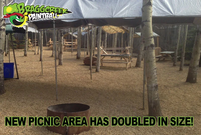 Bragg Creek Paintball picnic area with picnic tables under a canopy and message about doubling in size.