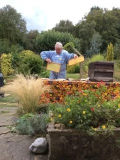 John Garner demonstrates how to collect honey from his beehives.