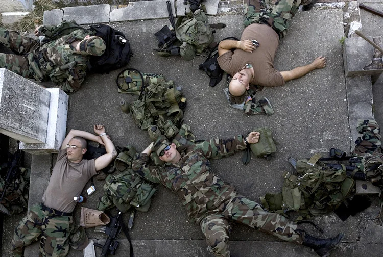  Exhausted National Guardsmen take a break at their temporary headquaters- Carrollton Cemetery. New Orleans, Tuesday Sept. 6, 2005. The National Guard Worked 24 hours a day, taking only short breaks for resst and food. 