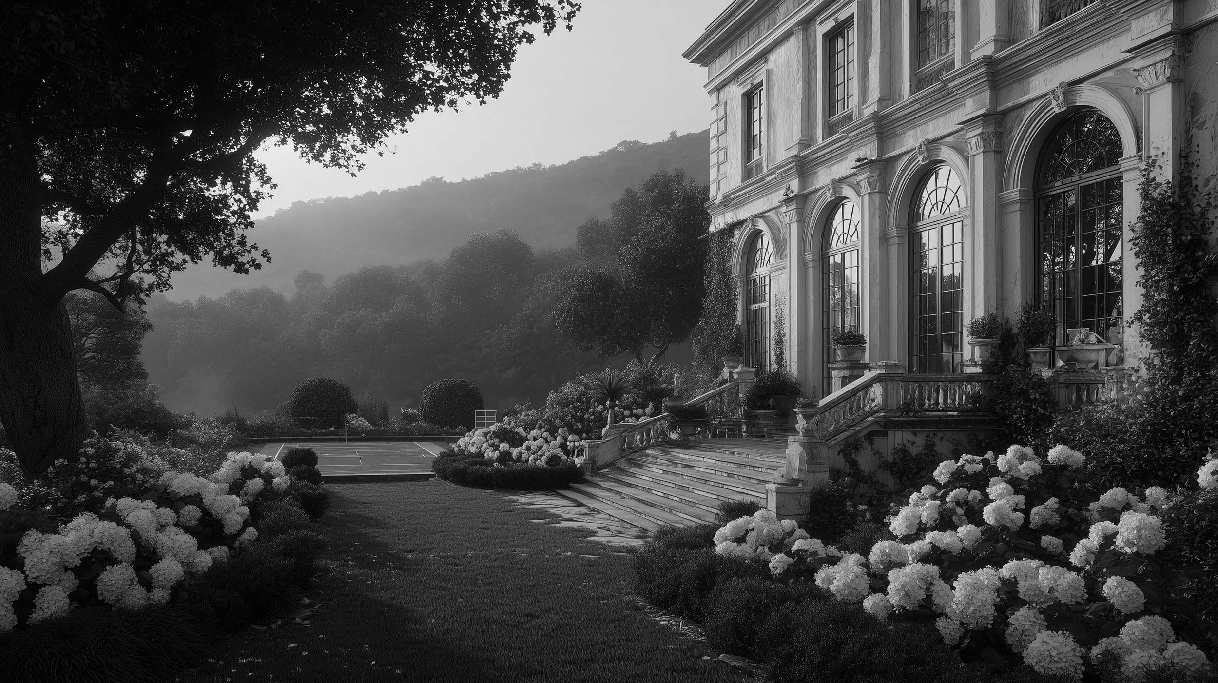 A large, elegant mansion with tall arched windows and stone stairs leading to the entrance, surrounded by landscaped gardens with blooming hydrangeas, trees, and a tennis court in the background, set against a mountainous backdrop.