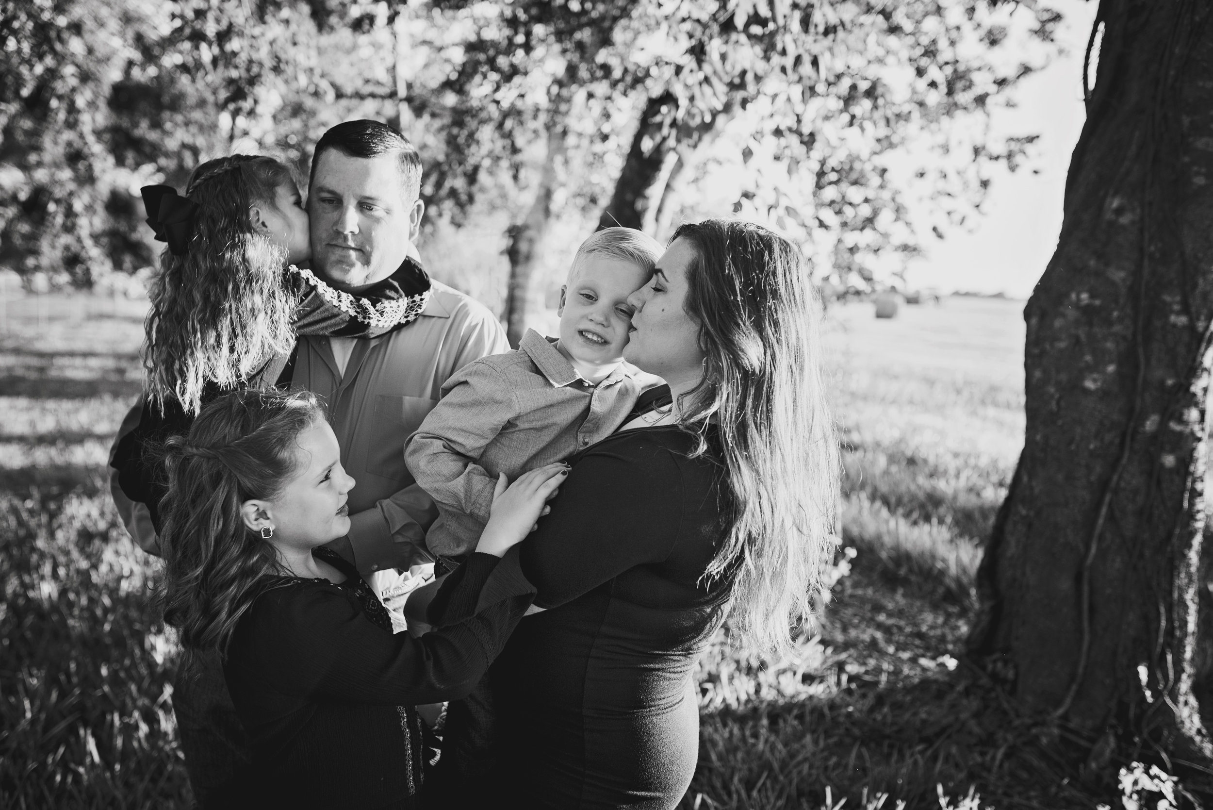 black and white kissing cheeks family pose