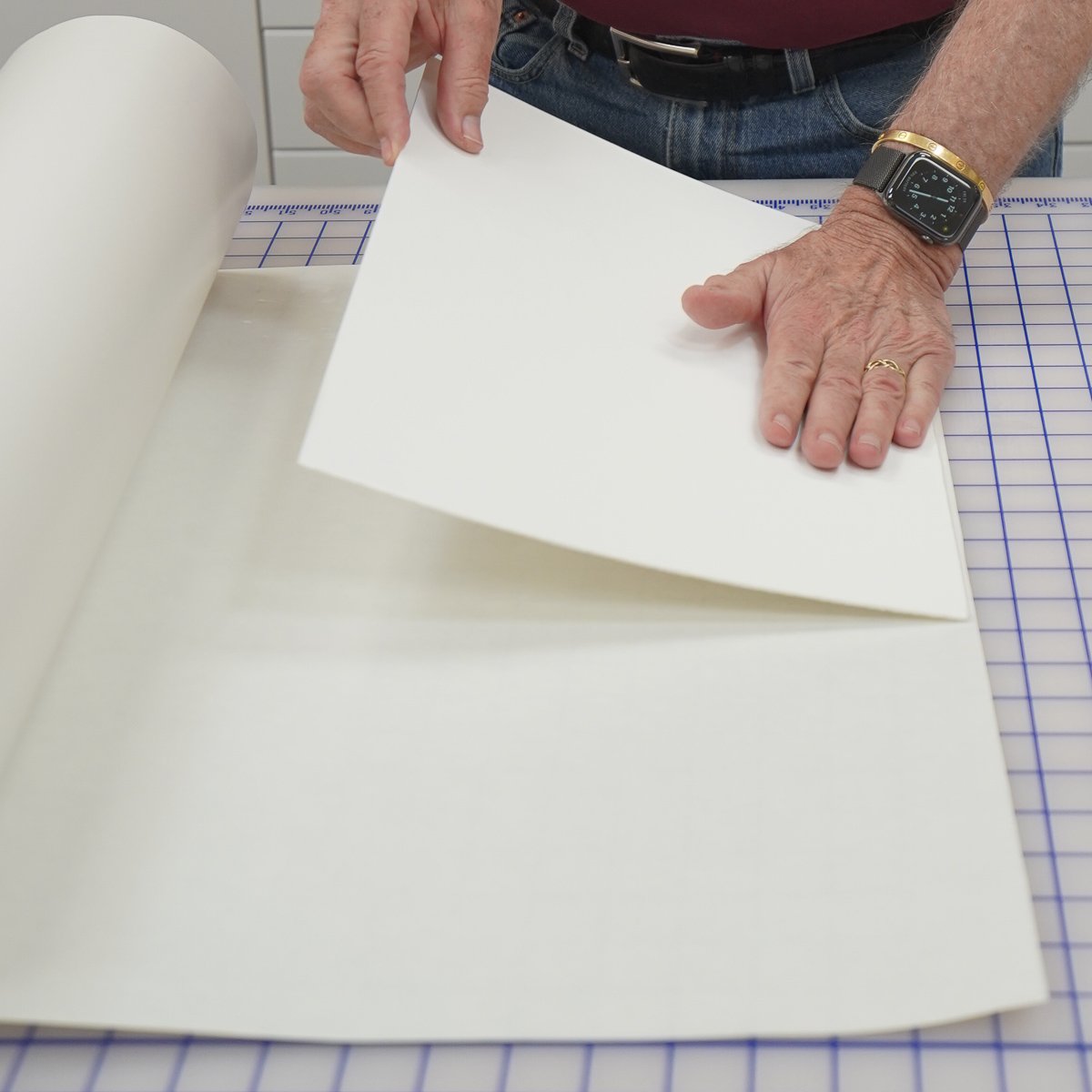  Once the print is fully dry, another overnight wait, the lamination process begins. Here you see a piece of acid-free mat board being pressed onto a sheet of adhesive film, a PH-neutral adhesive that is very aggressive and permanent. Any mishaps in 