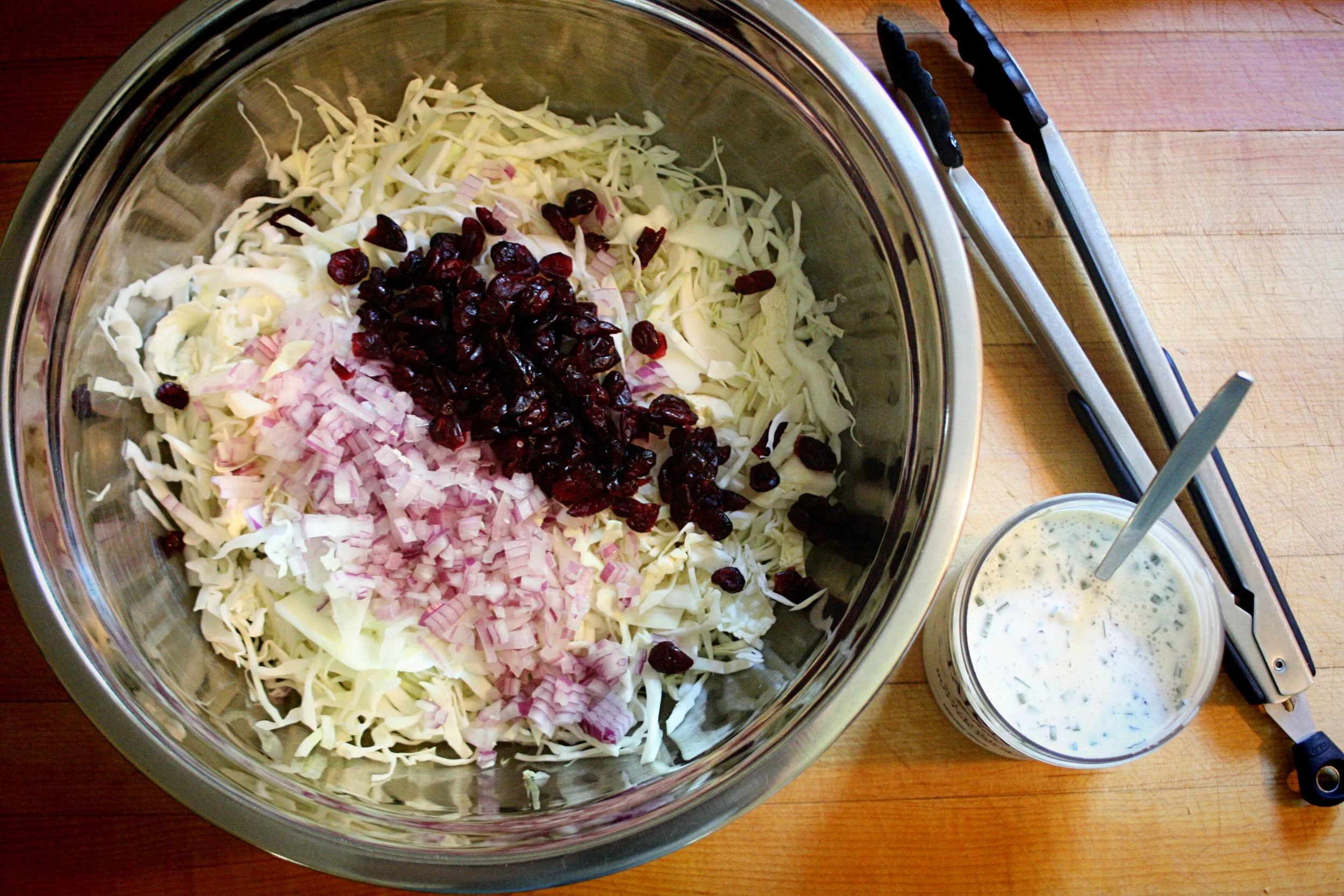 Pour the dressing over the fruit & veg and toss to combine. It is best if it can be made a little ahead of time so the cranberries release some of their sweetness. How much dressing? Well, I make a double batch to keep on hand, but a single is probably plenty for the cabbage slaw. You may even have extra. However, I would urge you to make more and keep it for salad. It is especially good on spinach!