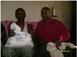 Michael (left) receiving mealie meal and a chicken from Mr. Stanley Mulenga