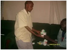 Stan giving ARV drugs to Justin at Stan’s home