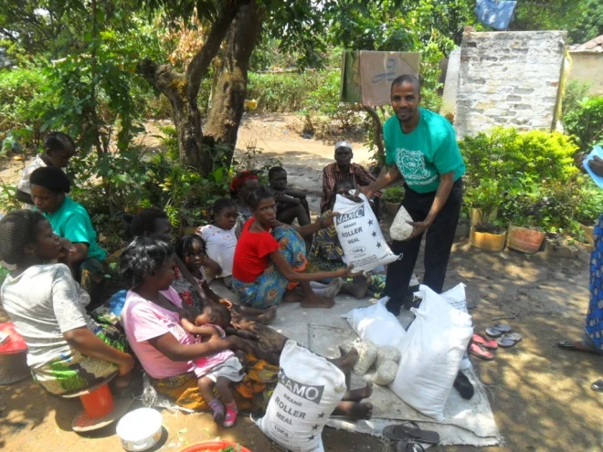 Stanley giving maelie meal and beans to Sharon Musonda in Buchi community