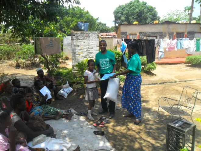Stanley (r) and Mwiche (l) giving melie meal to and beans to Judith Tembo