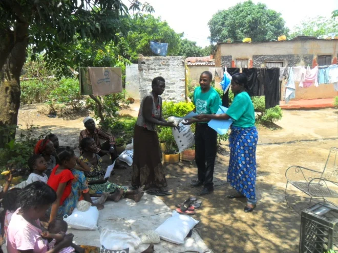 Stanley (l) and Mwiche Chomba (r) giving mealie meal and beans to Rodah Soko, a TB patient in Buchi community on 12th October 2011