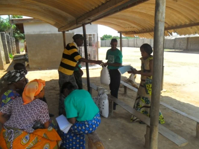 Stanley and Mary Kampyongo giving melie meal and beans to Forward Katukula