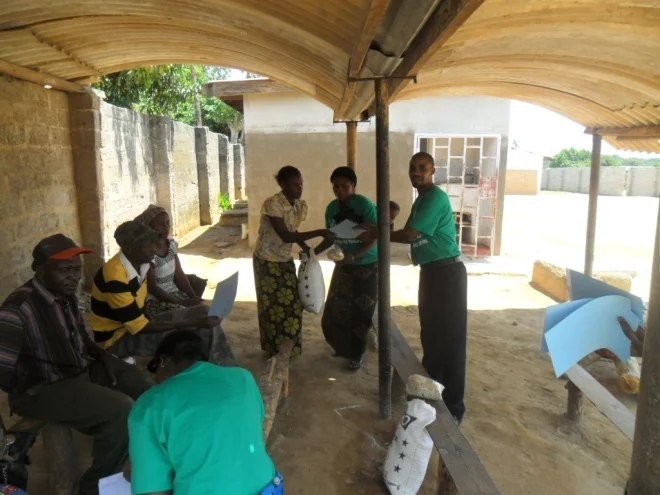 Bernadette and Stanley giving melie meal and beans to Ruth Kasongo in Kamatipa community on the 13th of October 2011