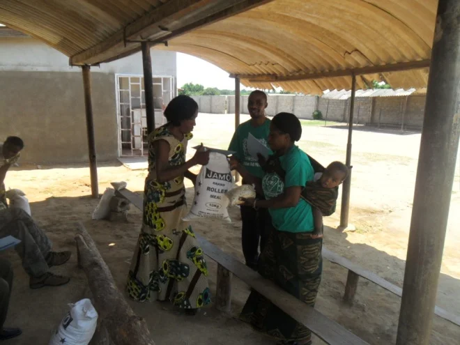 Bernadette and Stanley giving melie meal and beans to Mary Spriyano in Kamatipa community on the 13th of October 2011