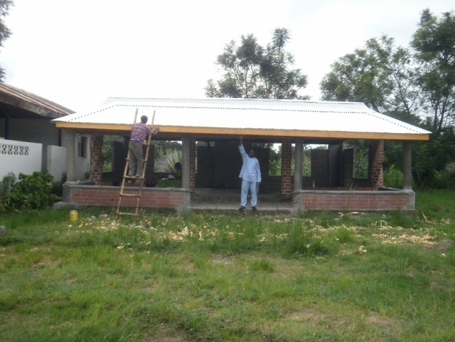 This is the new front view of Dr. Elizabeth Rini Medical Center with Isaac painting the facial board that Cliff has newly fixed. We will now install Dr. Elizabeth Rini Medical Center Sign in front of our center here