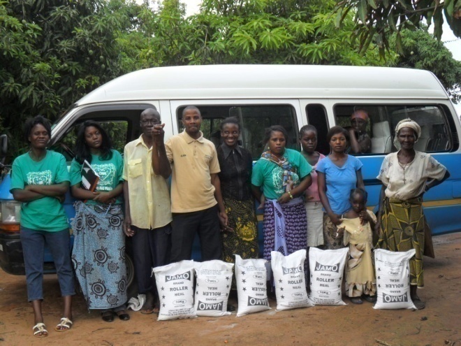 Stanley (in a brown T/Shirt), his wife Bernadette in a green T/shirt with a baby (Daniel) on the back, Mwiche (in green) with Kamakonde community volunteers and the TB patients posing for a photo in Kamakonde community