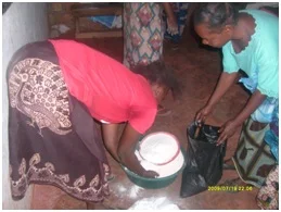 Catharine’s first born daughter (in red) sharing mealie meal to Christine Buleti out TB and HIV/AIDS patient in St. Anthony community