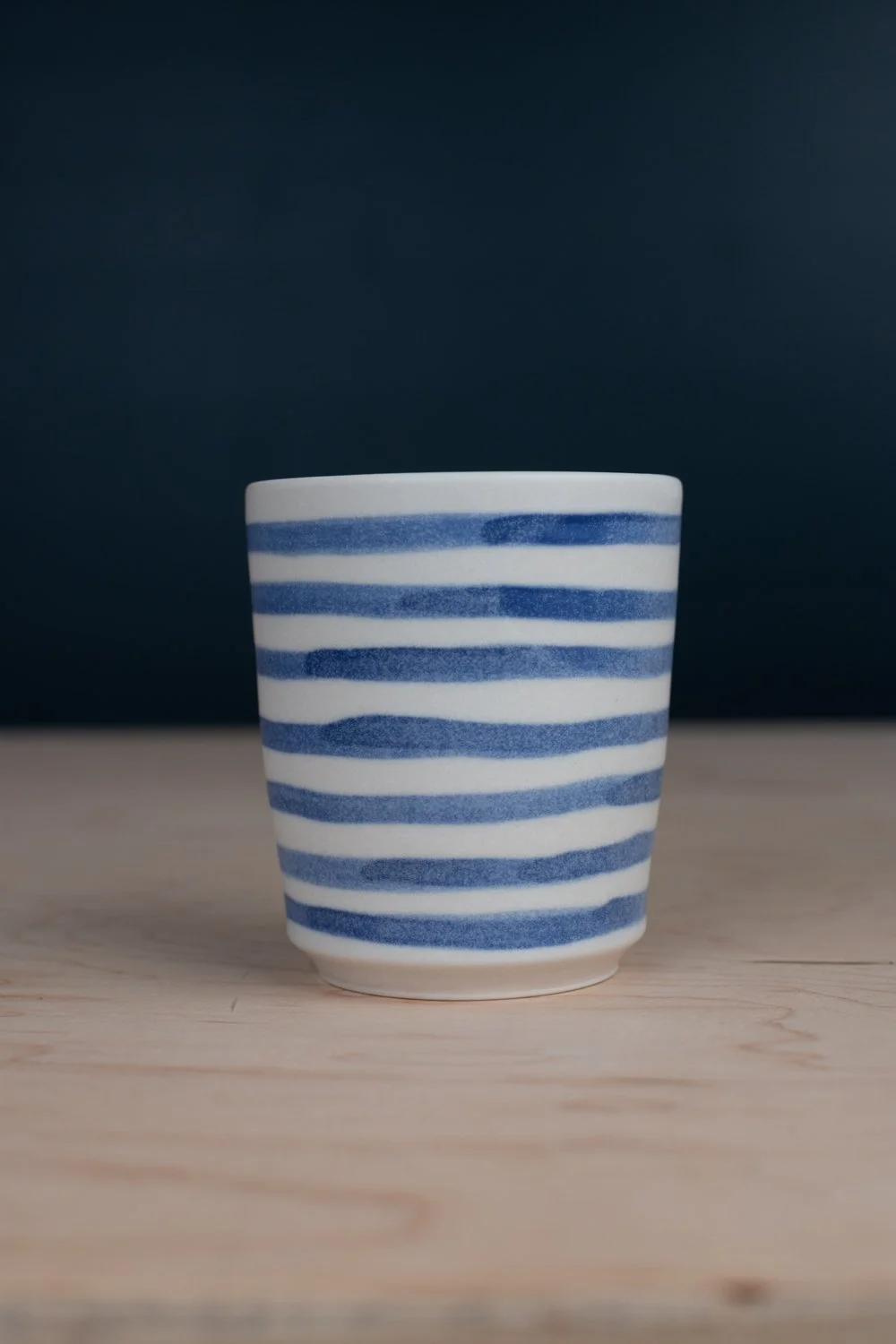 Blue and white porcelain mug with hand-painted illustration by Eleanor Annand.