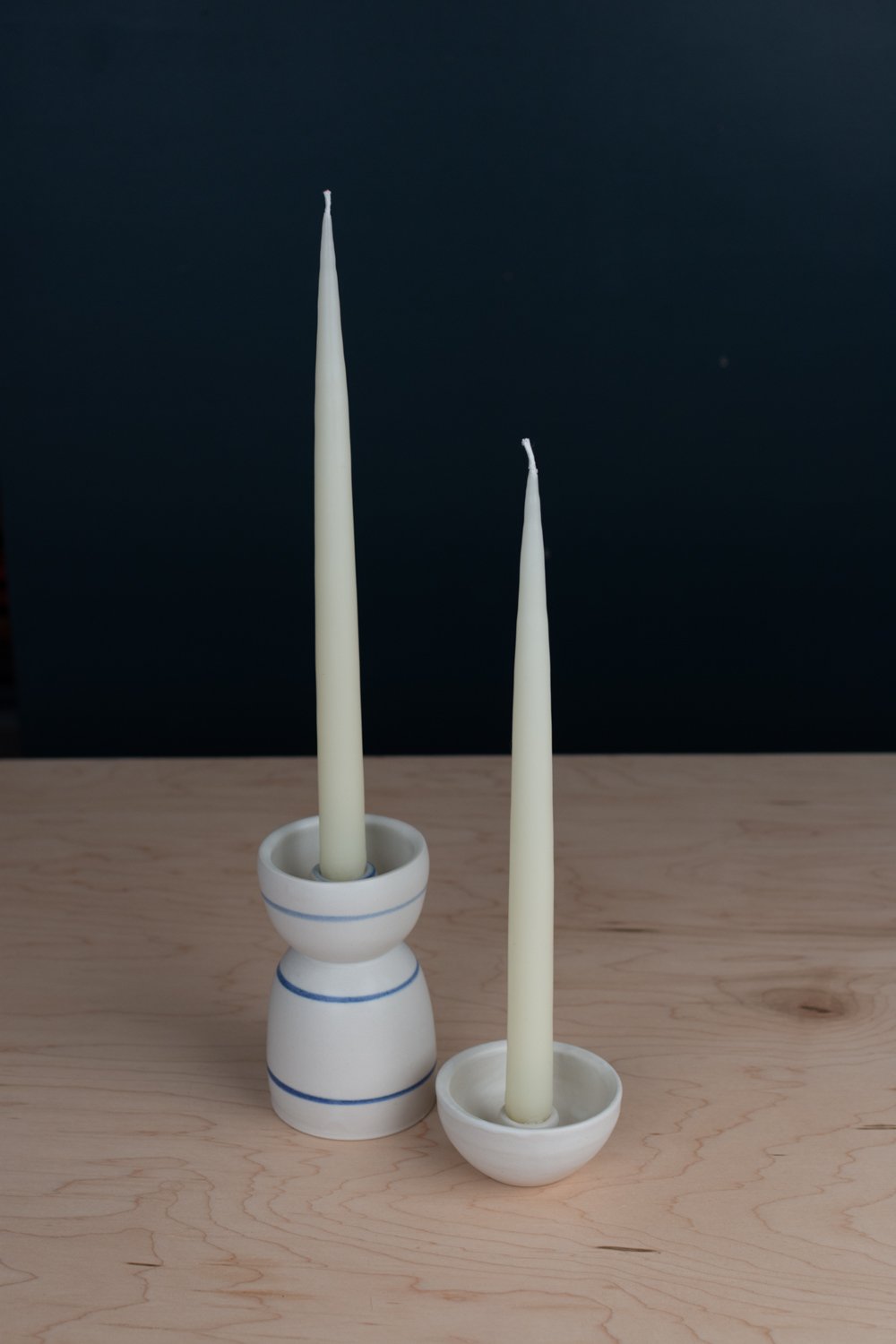 Hand-thrown porcelain candle holder set with blue stripes.