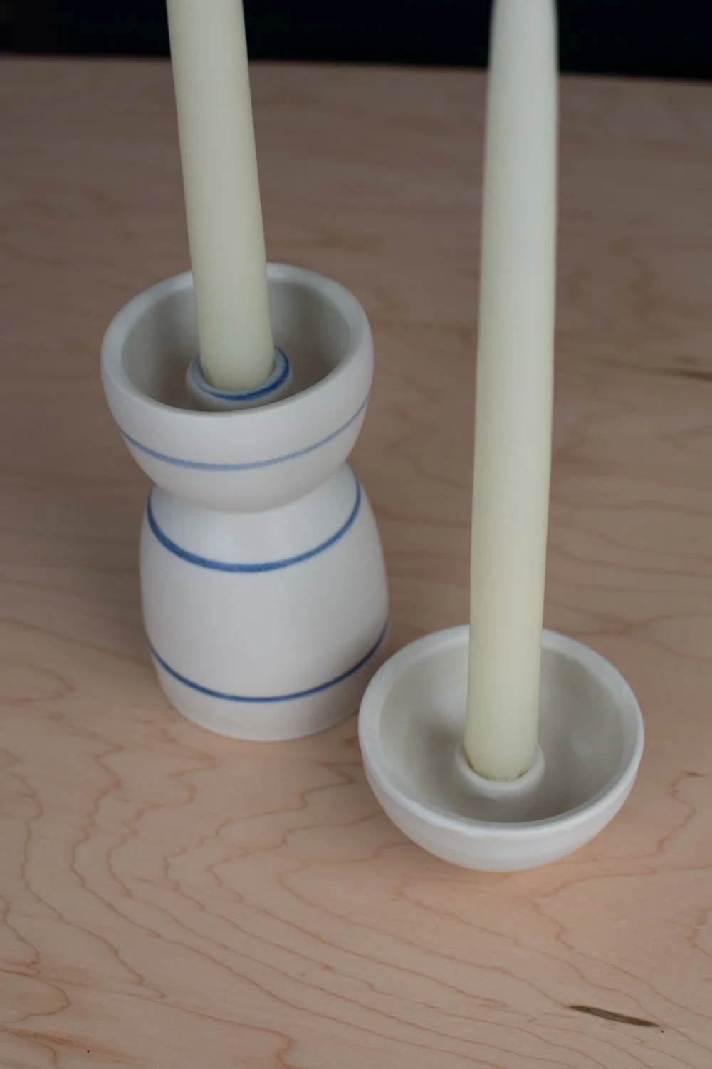 Hand-thrown porcelain candle holder set with blue stripes.