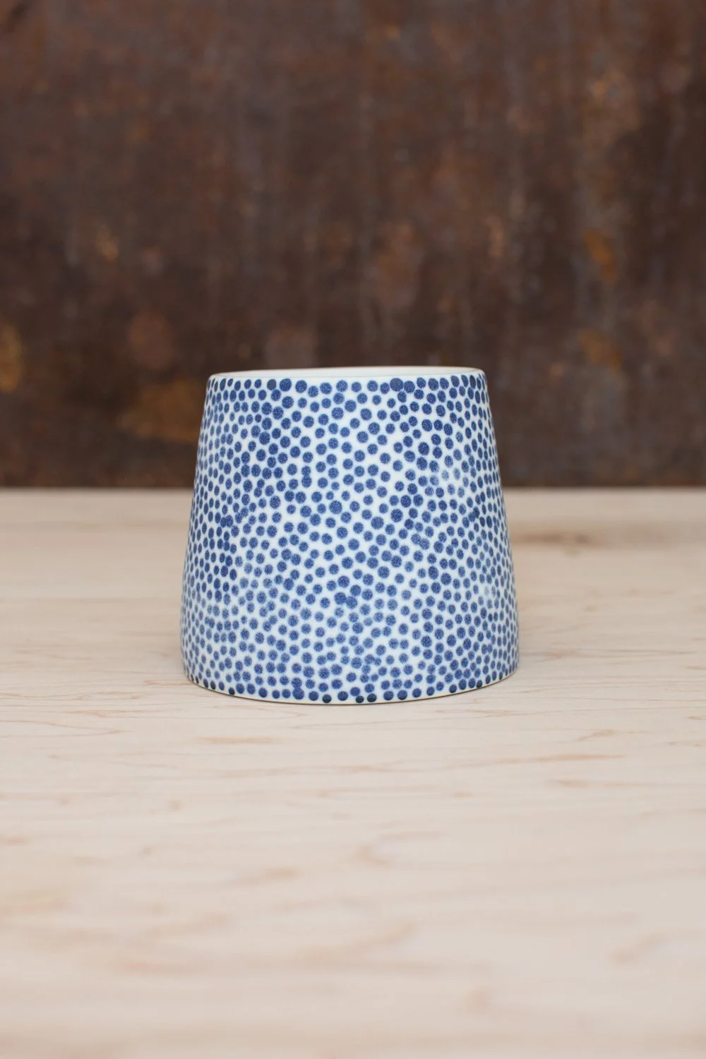 Hand-thrown porcelain mug with blue dots.