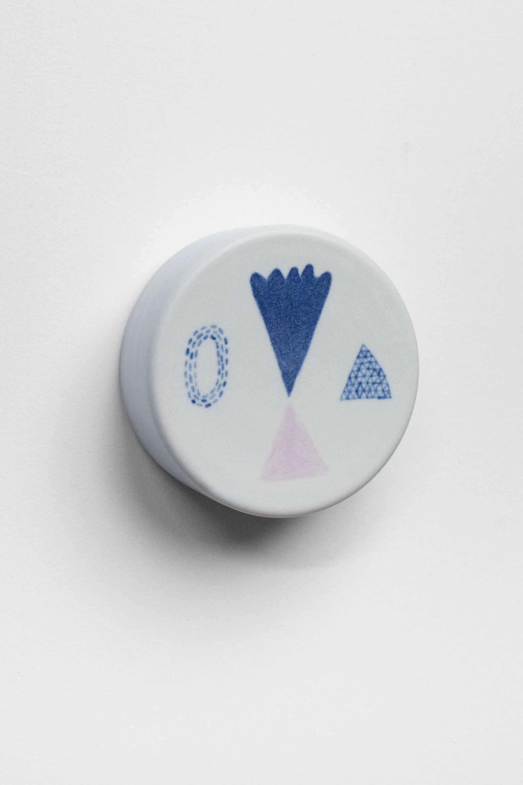 Hand-painted, ceramic, wall hanging sculpture with blue and lilac underglaze over creamy white porcelain.