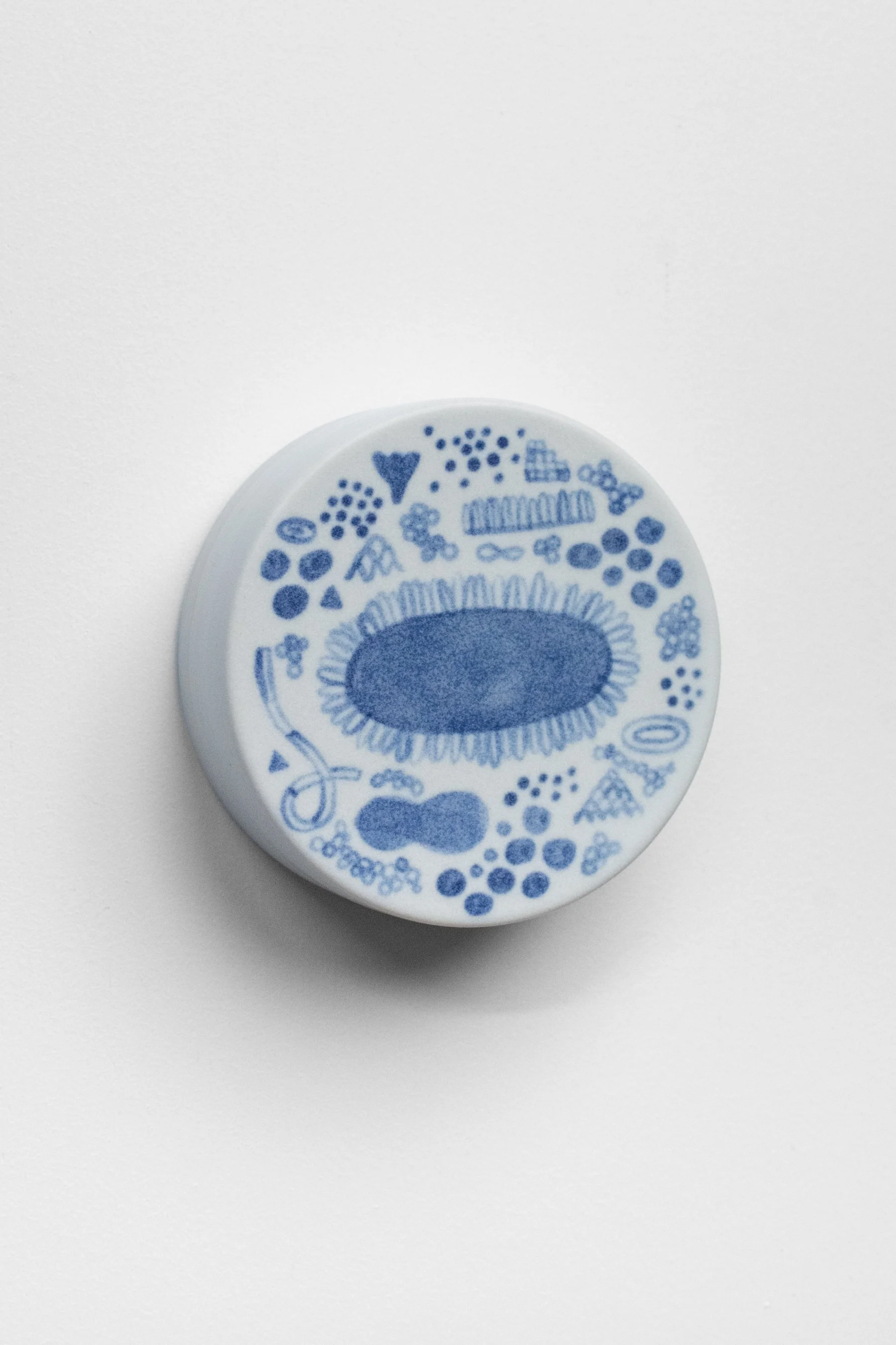 Hand-painted, ceramic, wall hanging sculpture with blue underglaze over creamy white porcelain.