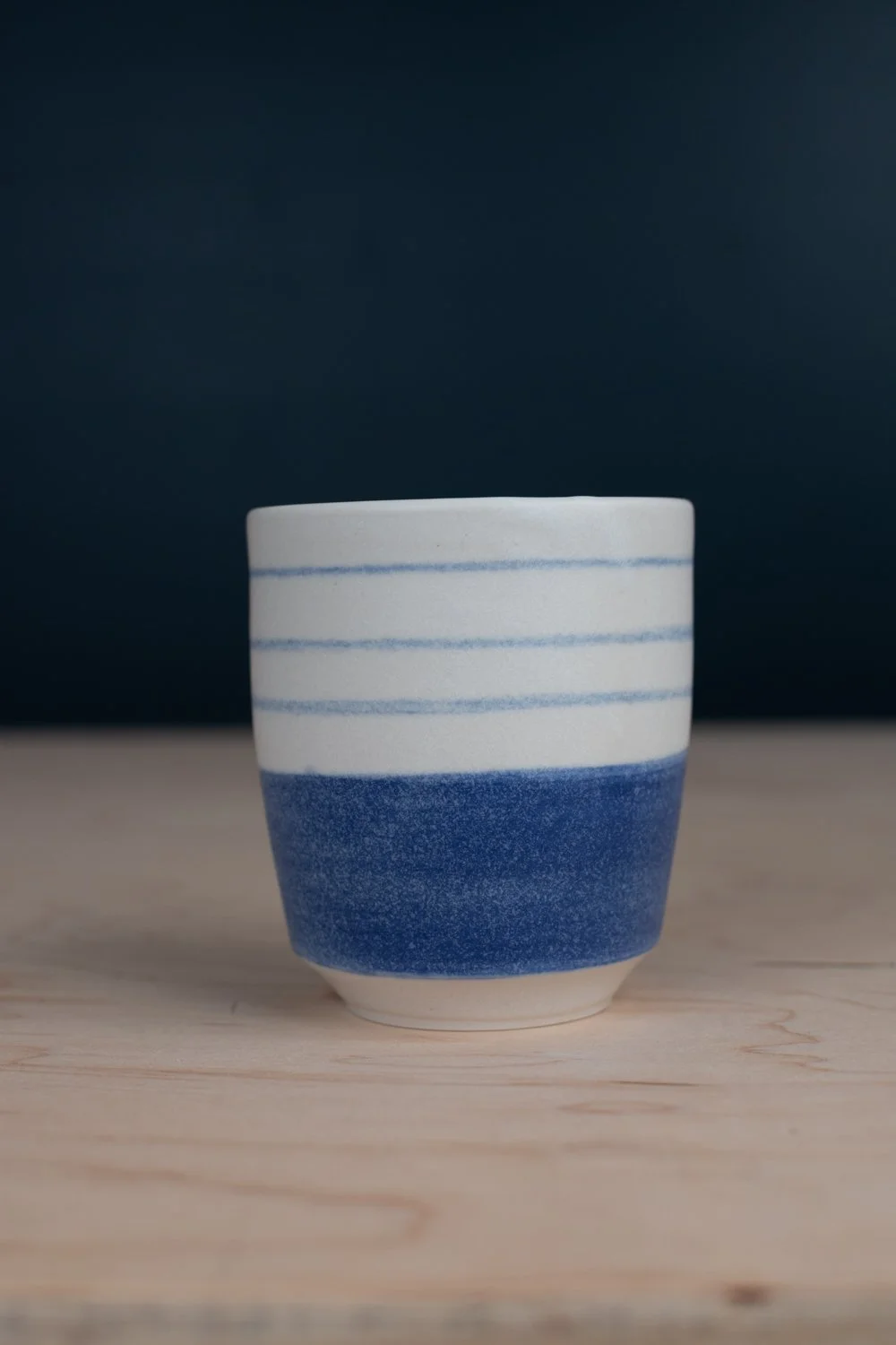 Blue and white porcelain mug with hand-painted illustration by Eleanor Annand.