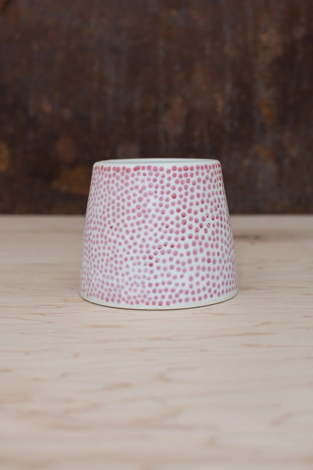 Hand-thrown porcelain mug with red dots painted on the surface.
