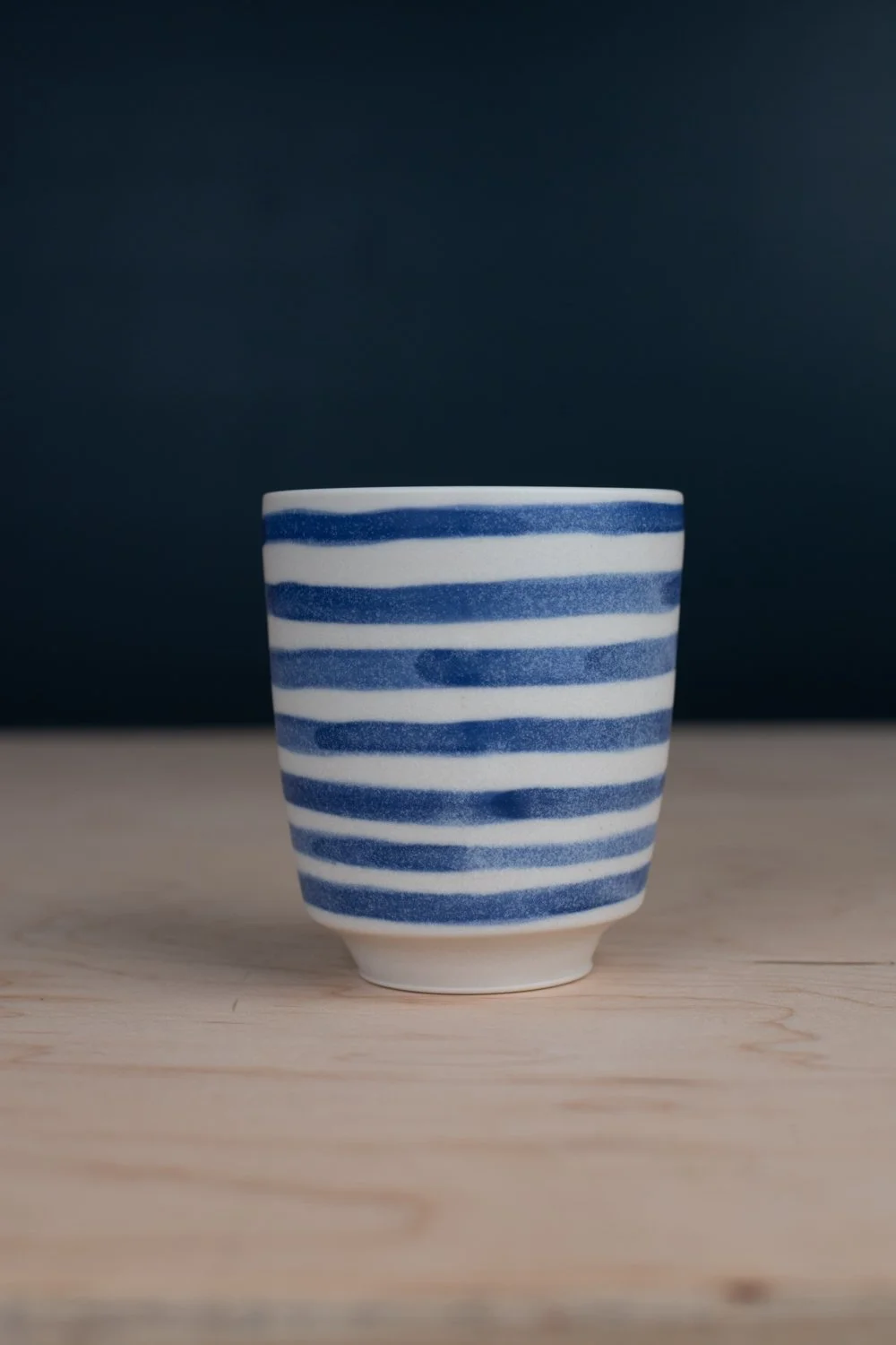 Blue and white porcelain mug with hand-painted illustration by Eleanor Annand.