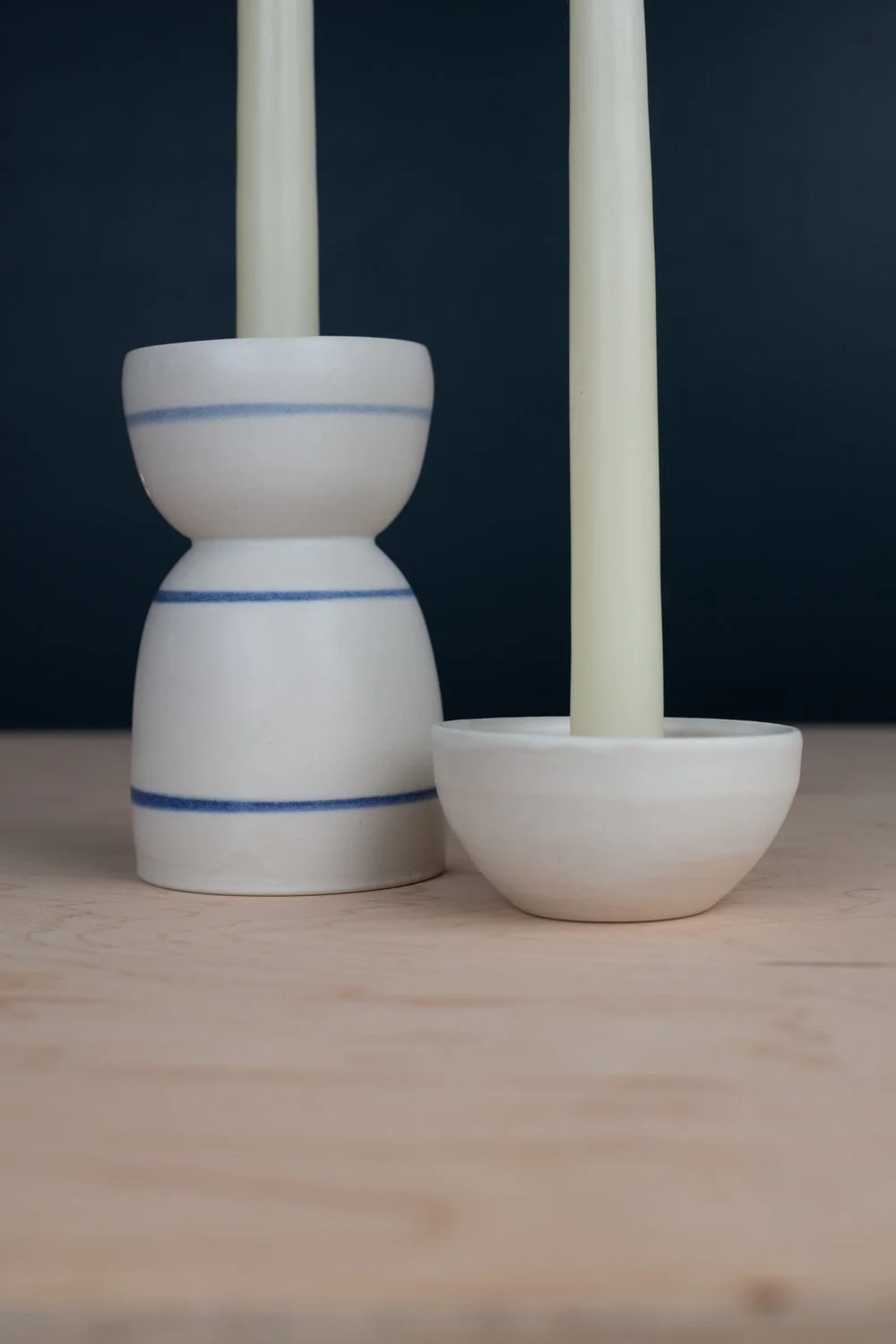 Hand-thrown porcelain candle holder set with blue stripes.
