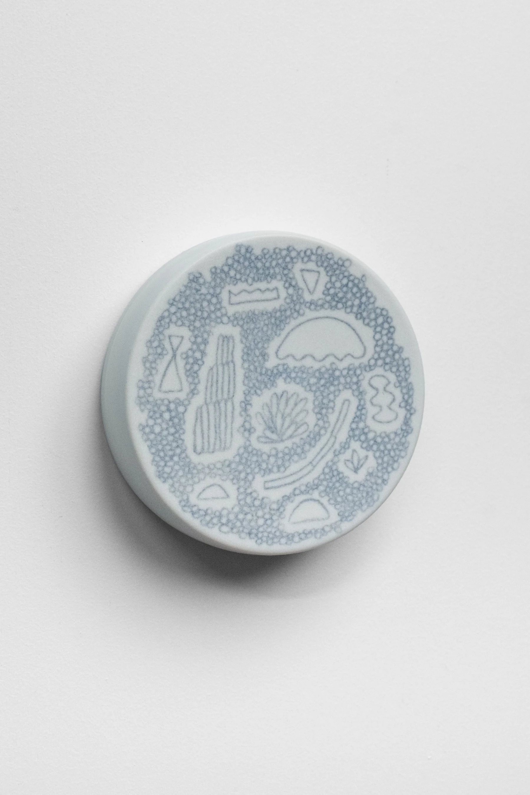 Hand-painted, ceramic, wall hanging sculpture with black underglaze over creamy white porcelain.