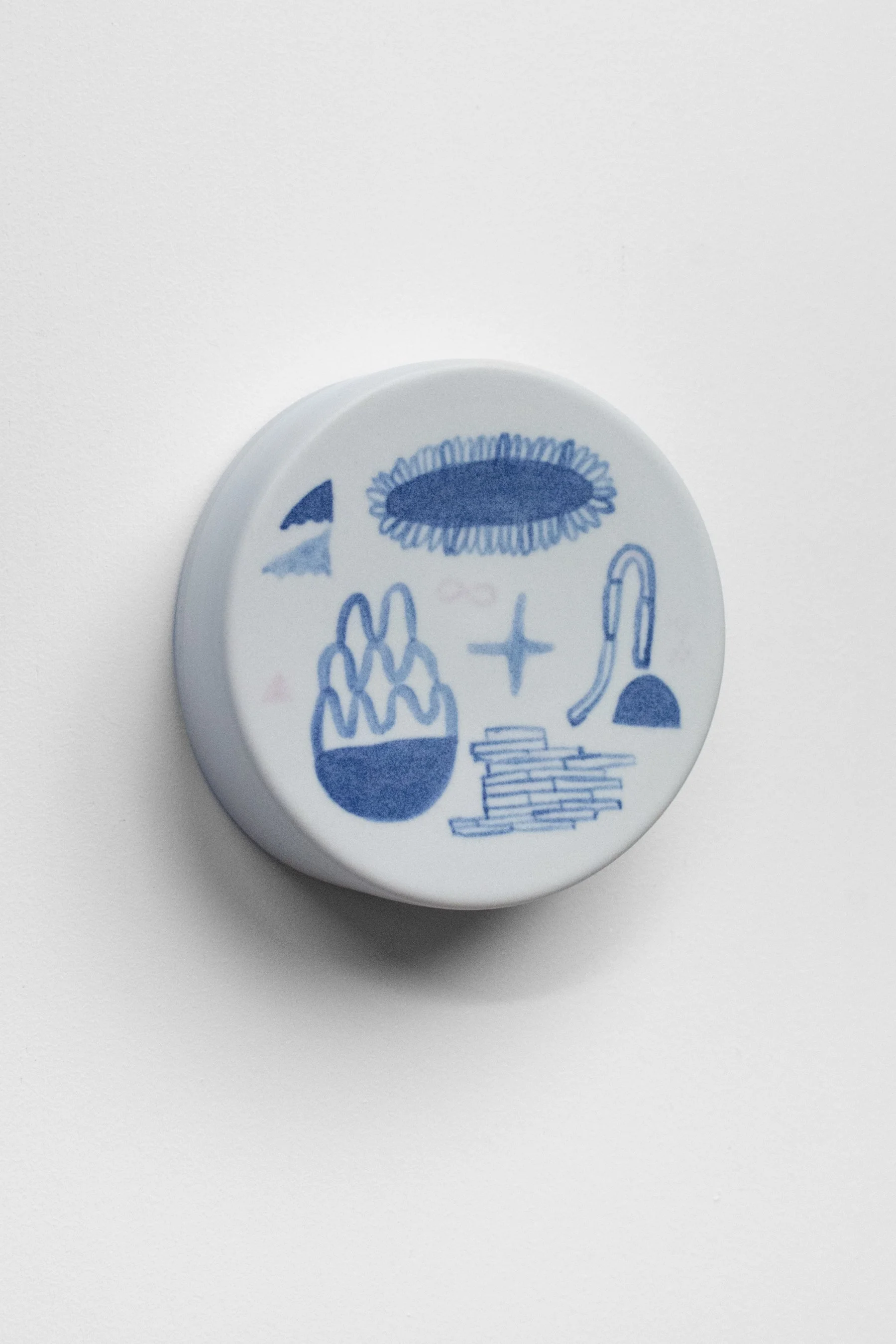 Hand-painted, ceramic, wall hanging sculpture with blue underglaze over creamy white porcelain.