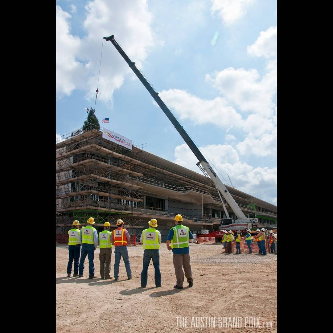 Proud workers watch as a symbolic tree is hoisted to the top of the building to commemorate the Topping Out at COTA on April 12, 2012. #F1 #USGP #COMEANDRACEIT