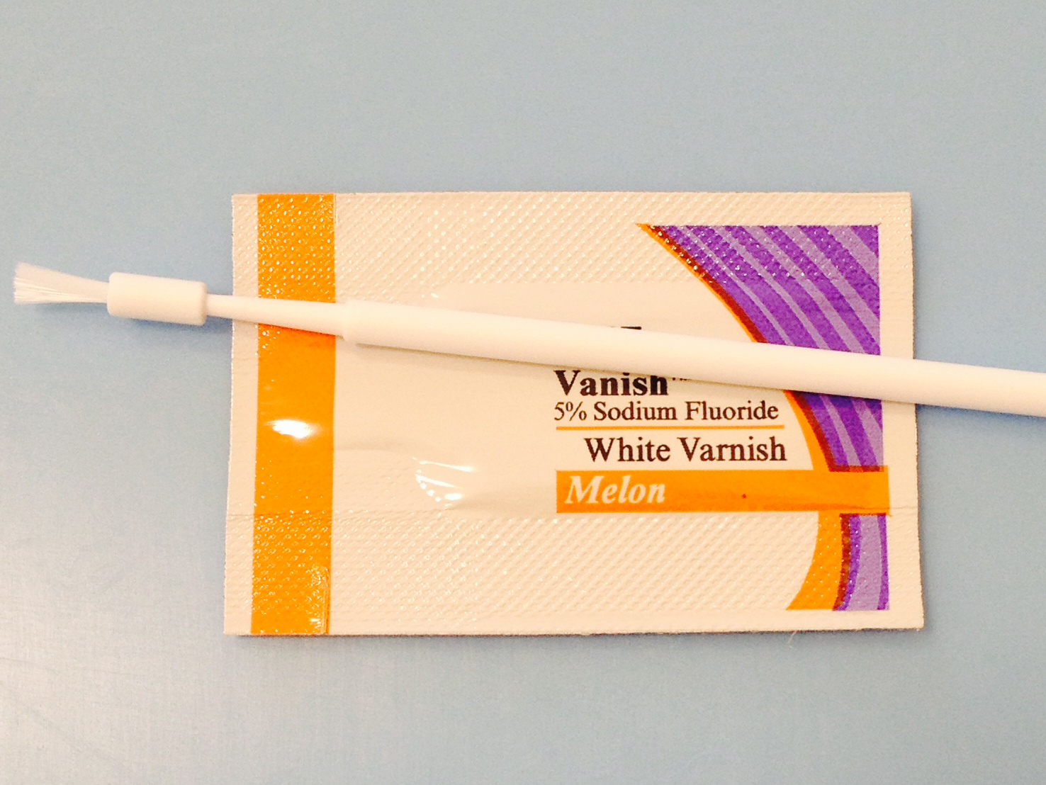 One example of fluoride varnish with its applicator.