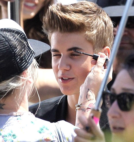 Makeup artist applying brow gel to pop star Justin Bieber.