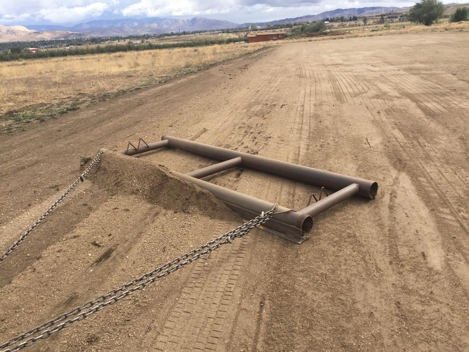The runway surface is groomed with a drag after rain storms. 2015