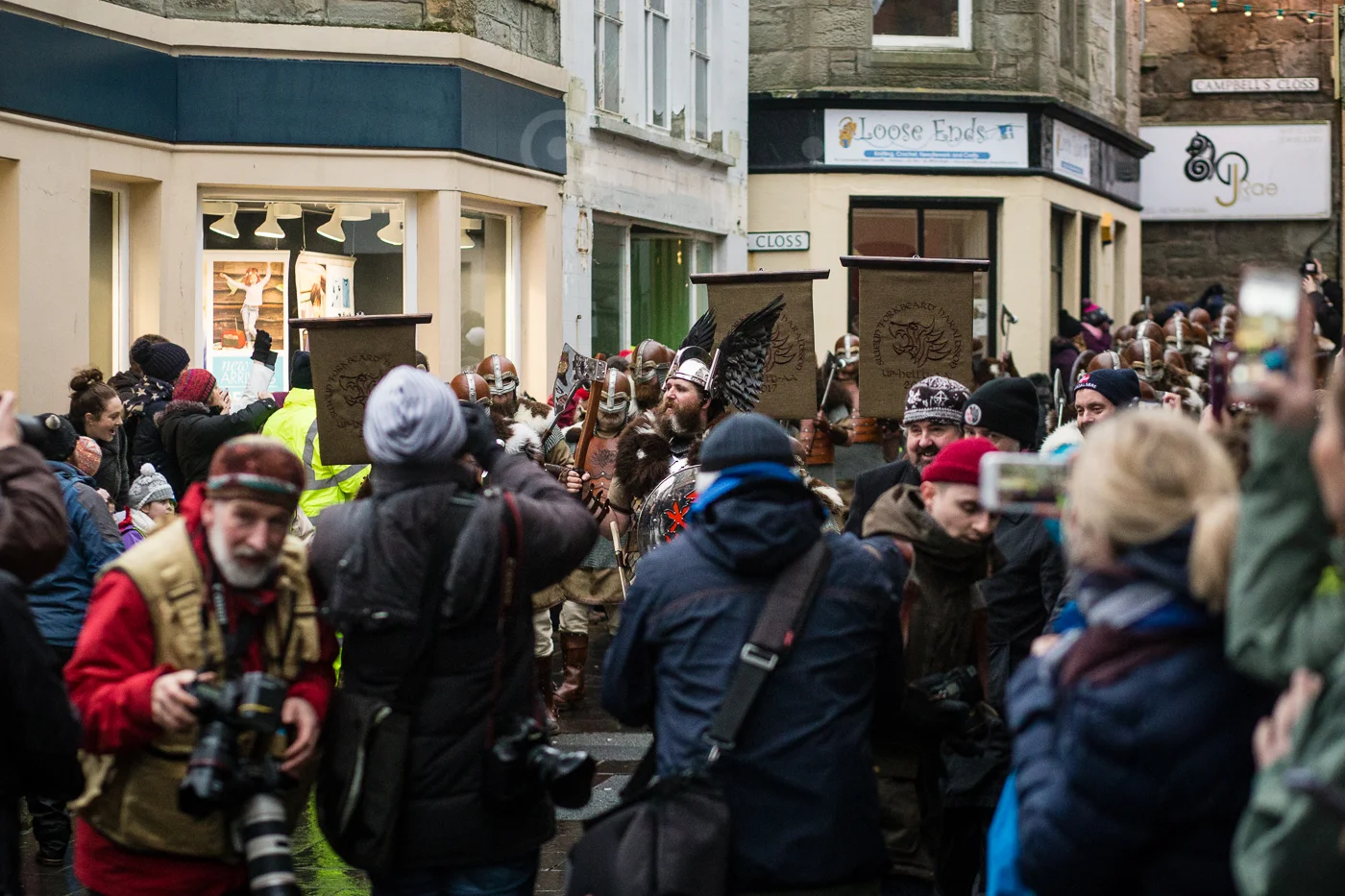 The press throng around the Jarl's Squad as they come through the centre of town.