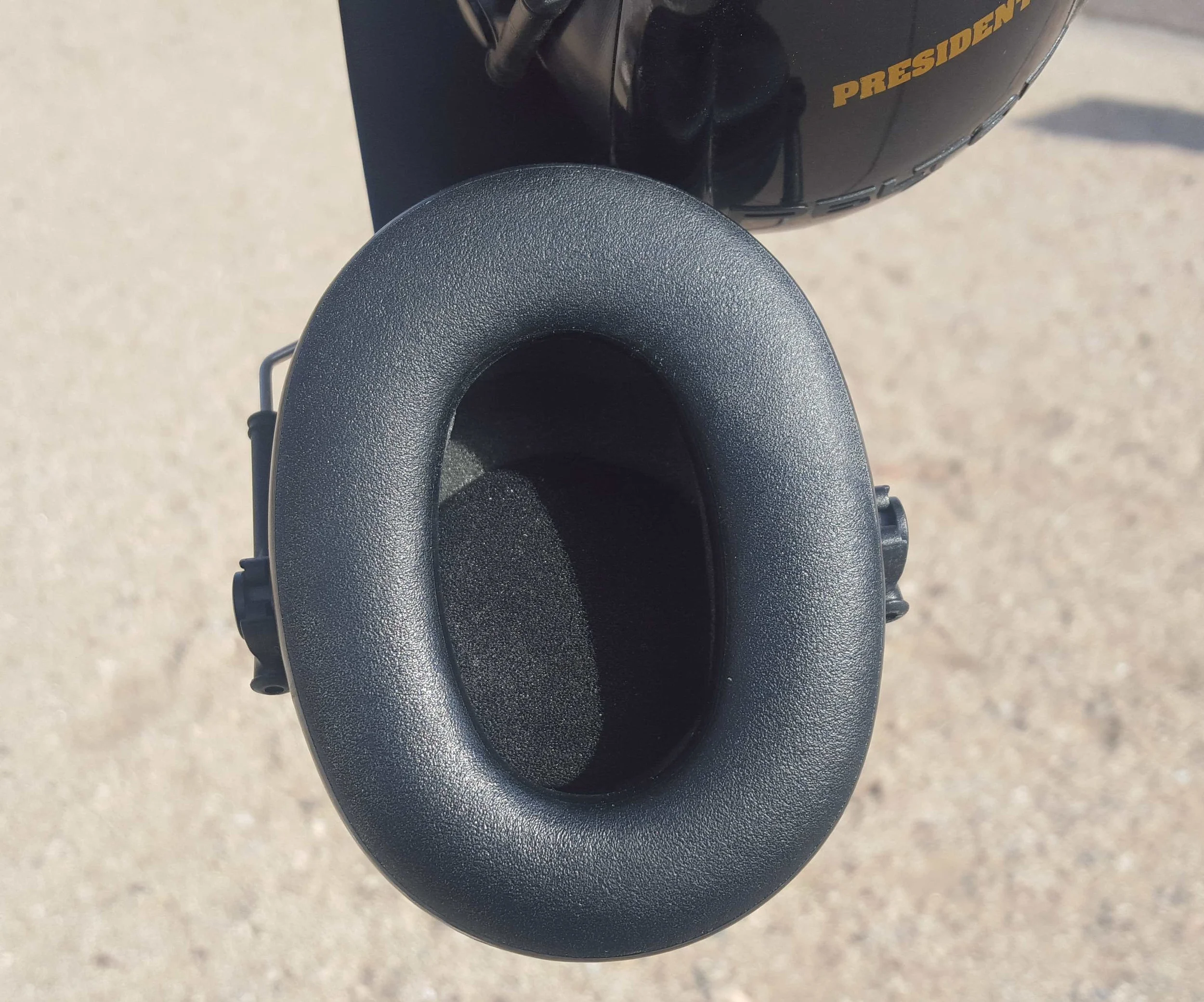 The wire goes behind the noise-blocking foam