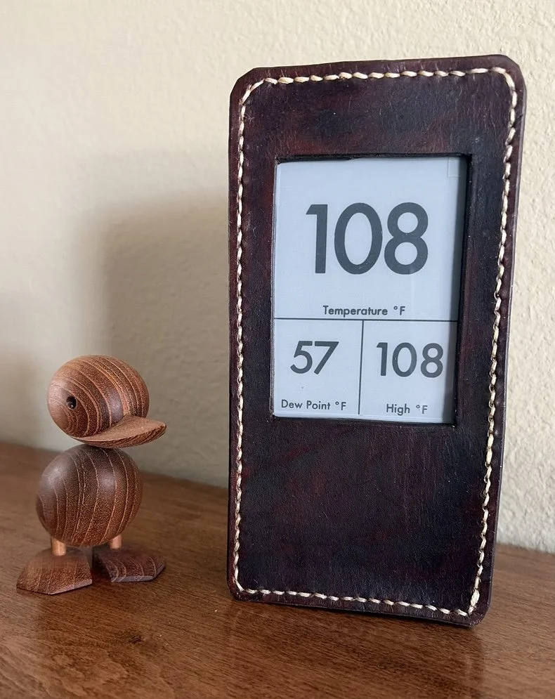 A janky leather box holds the weather station display