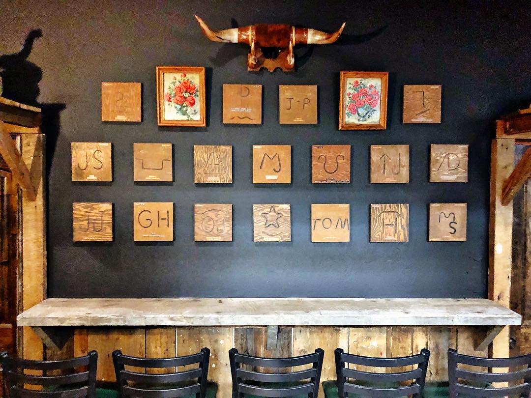I finished hanging the brands in the back room at the bar and got most of the “ranch life” decor and taxidermy up. It’s so cool to have this collection as a part of the bar! There are 50 wooden plaques each branded with family cattle .jpg