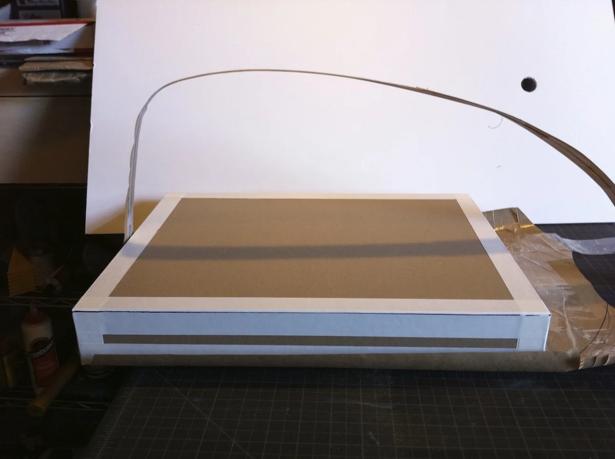 The box with the white tape around the edges is a stand in for the space required for the laptop and the drawing tablet.