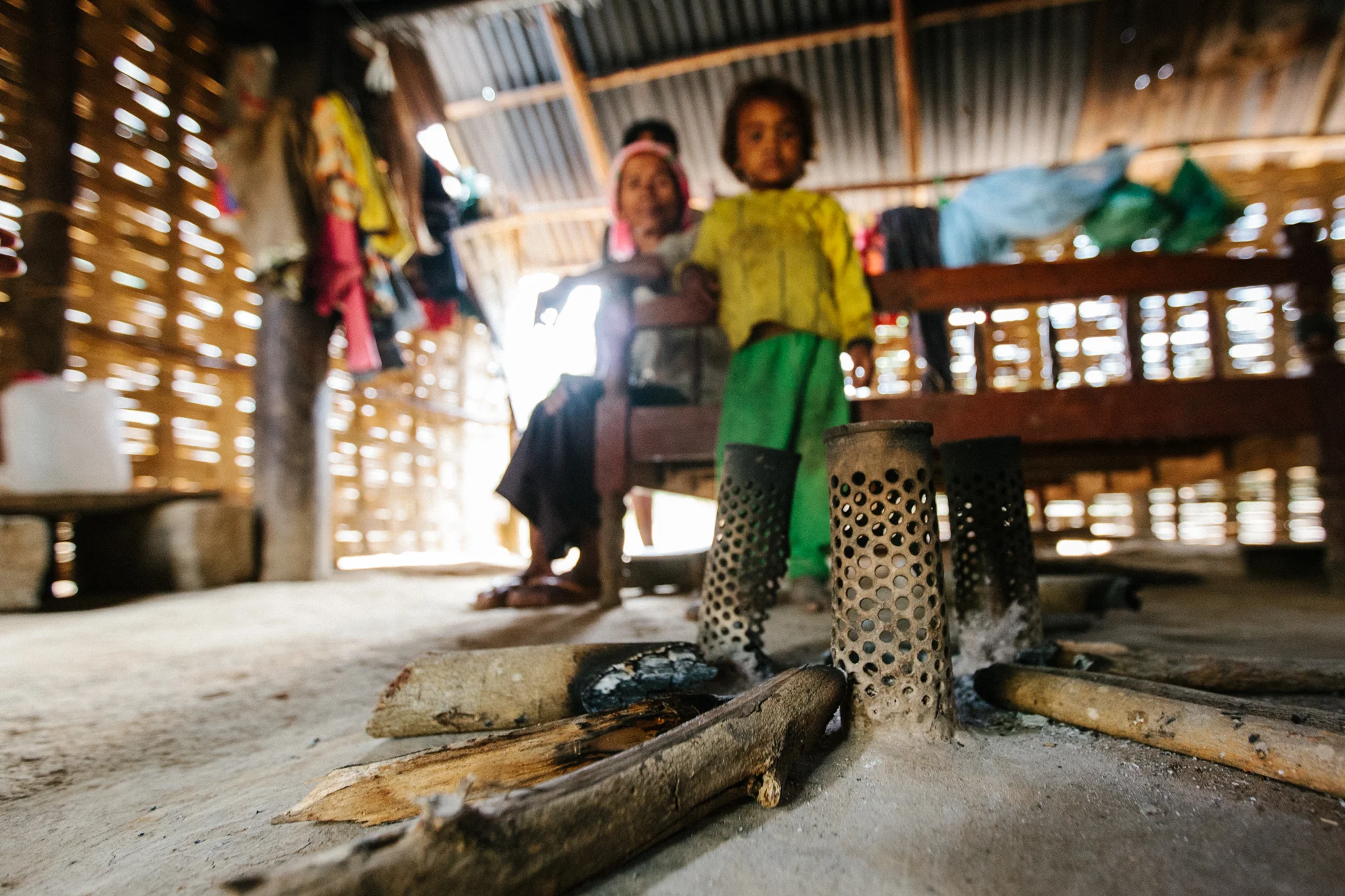 A Monong ethnic minority family gathers around their stove, made from recycled landmines, in Vietnam.